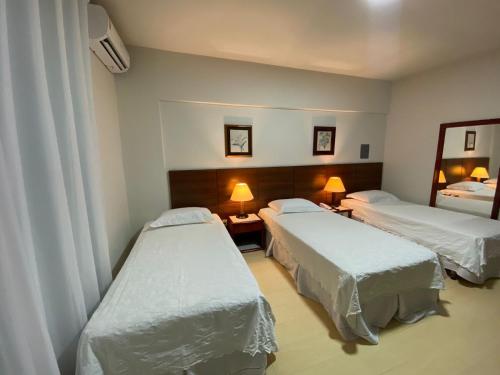 波多韦柳AQUARIUS HOTEL的酒店客房,设有两张床和镜子