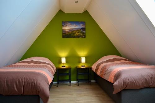 佐特兰德Luxe vakantievilla Zoutelande的绿墙客房的两张床