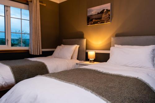 Atlantic views at Arnisdale House的酒店客房设有两张床和窗户。