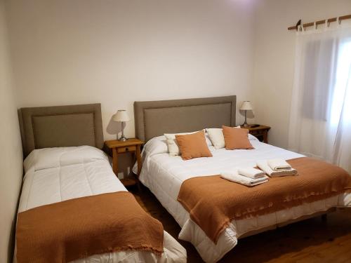 拉库布蕾Posada de la Montaña的一间卧室设有两张床和两张带台灯的桌子。