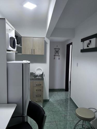 马卡埃Flat Bela Vista的厨房配有冰箱、桌子和椅子