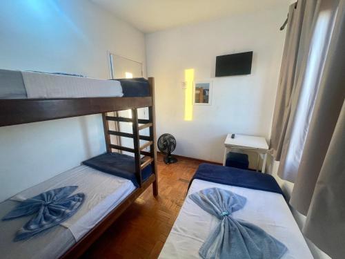 布拉干萨-保利斯塔Pousada Casa de Bragança的一间卧室配有两张双层床和蓝色弓