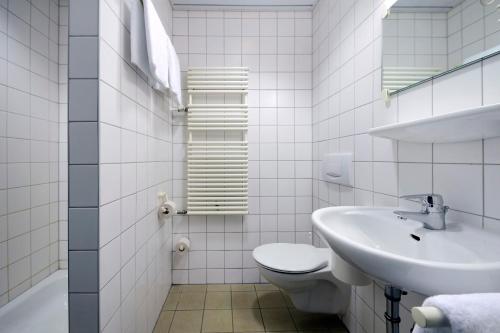 苏尔Olympia Hotel Suhl的白色的浴室设有水槽和卫生间。