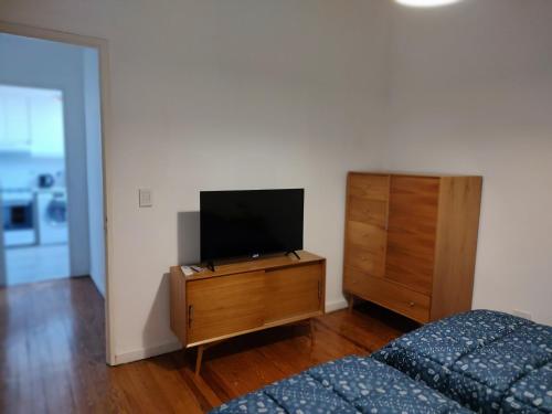 布宜诺斯艾利斯Caminito Apart的一间卧室配有一张床,梳妆台上配有电视