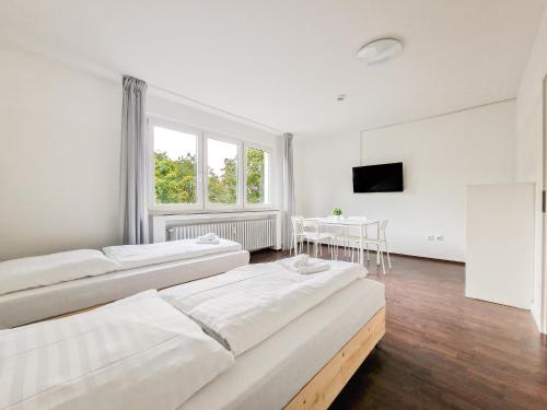 杜伊斯堡RAJ Living - 1 or 3 Room Apartments - 30 Min Messe DUS的白色的客房设有三张床和一张桌子