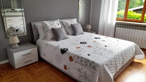 Invorio InferioreCasa Germana的卧室配有一张带白色被子和镜子的床