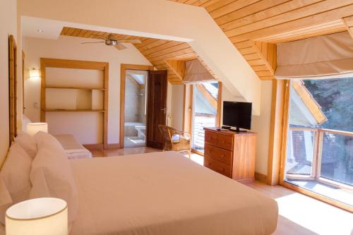 拉安戈斯图拉镇科伦托索湖与河酒店的一间卧室配有一张床,并在一间客房内配有电视。