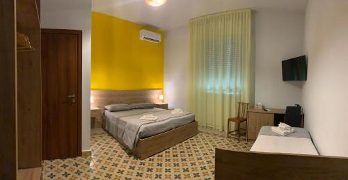 雷焦卡拉布里亚Erythrà Bed and Breakfast的一间卧室设有一张床和黄色的墙壁