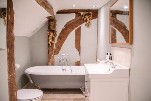 拉文纳姆Rose Cottage in Lavenham的带浴缸、卫生间和盥洗盆的浴室