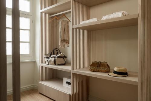 埃尔莫波利斯SYROS SOUL LUXURY SUITES的步入式衣柜,配有白色的架子和窗户