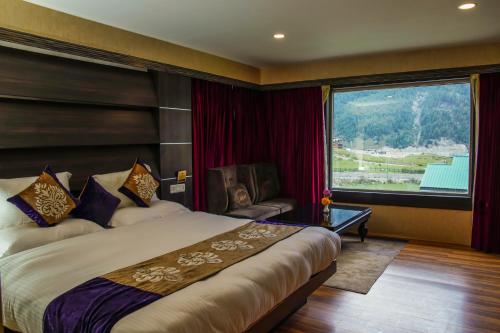 索纳马格Arco Hotels & Resorts sonamarg的酒店客房设有一张床和一个大窗户