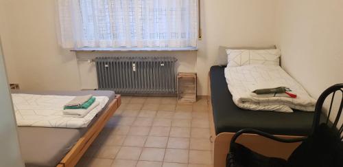 施韦青根Joanna Apartment - Schwetzingen 2的小房间设有两张床和窗户