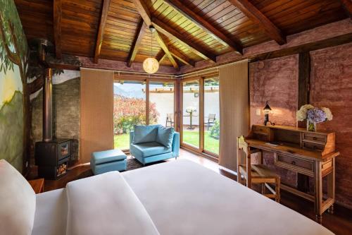 巴尼奥斯Luna Volcán, Adventure SPA的一间卧室配有一张床、一张桌子和一把椅子