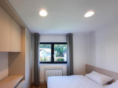 克卢日-纳波卡Royal Maison Apartments的一间卧室设有一张床和一个窗口