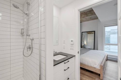 魁北克市INITIAL / Parisianer / Centre-ville de Québec的带淋浴和盥洗盆的白色浴室