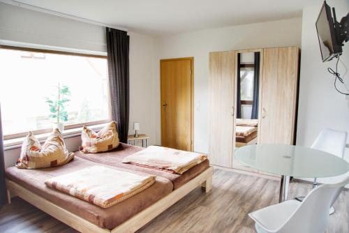 MönkebudeHaff Ostseeferienhaus unteres Apartment的一间卧室配有一张床和一张玻璃桌