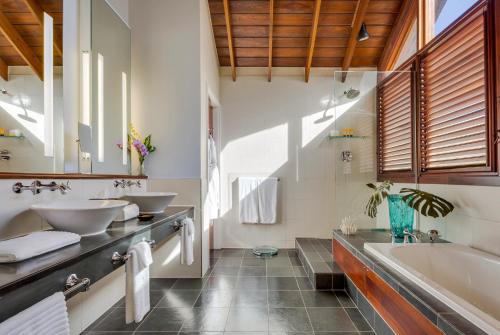马里戈特湾Zoetry Marigot Bay - All Inclusive的浴室配有2个盥洗盆和1个浴缸。