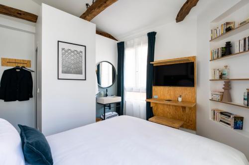 巴黎Baba Hotel的卧室配有白色的床和镜子