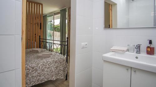 滨海阿雷尼斯Holidays en Arenys de Mar y Montaña的白色的浴室设有水槽和一张床