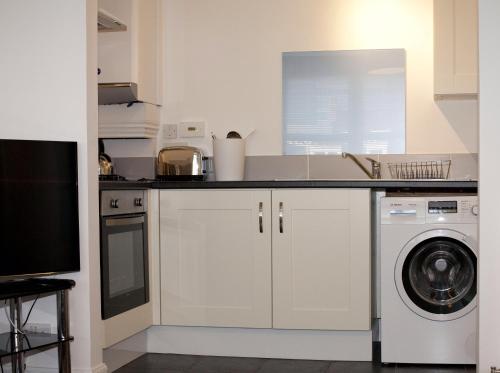 阿伯丁夏洛特街阿伯丁服务公寓的厨房配有水槽和洗衣机