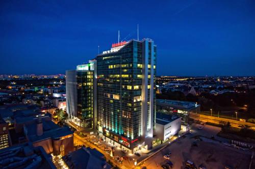 波兹南Andersia Hotel & Spa Poznan, a member of Radisson Individuals的一座高大的建筑,上面有灯,晚上