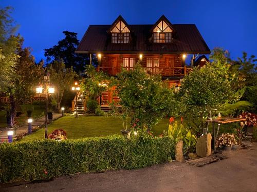 努沃勒埃利耶昆士伍德小屋酒店的一座大型木屋,晚上有院子
