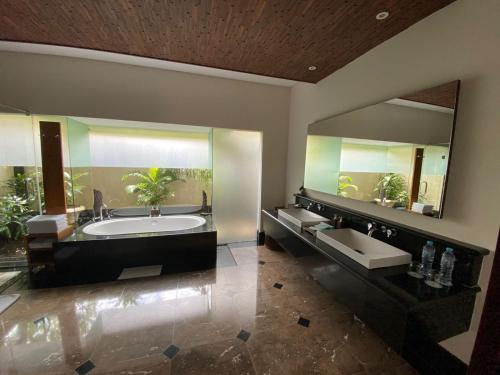 库塔登巴厘别墅的一间带两个盥洗盆和大镜子的浴室