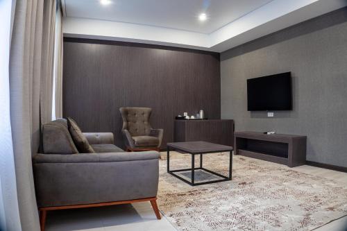 阿拉木图Resident Hotel Kazybek Bi的带沙发和电视的客厅