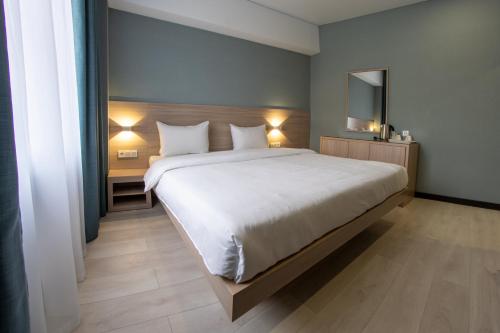 阿拉木图Resident Hotel Kazybek Bi的卧室配有一张带两个枕头的大白色床