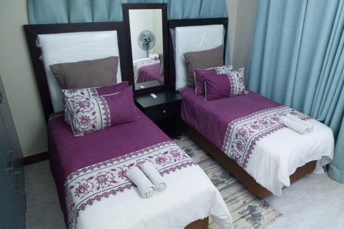 利文斯顿Netflix/WI-FI, 3 bedroom and free parking的一间卧室配有两张紫色和白色床单