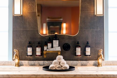 韦斯特维克Slottsholmen Hotell och Restaurang的浴室配有带镜子的盥洗盆和瓶子