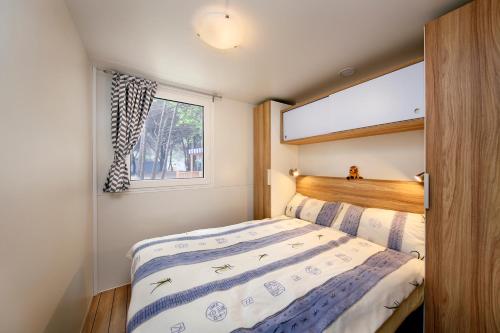 卡里高多Albatross Mobile Homes on Camping Park Umag的一间小卧室,配有床和窗户