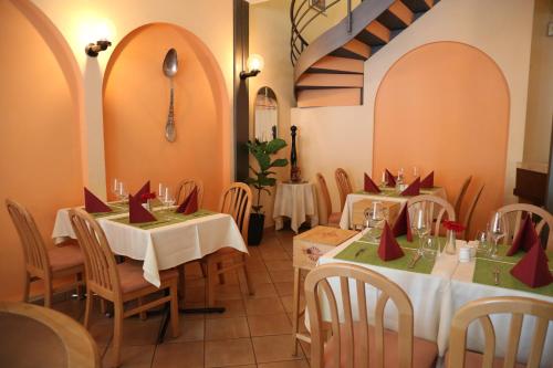 洛迦诺Al Pozz Boutique Resort的餐厅设有2张桌子和椅子,并配红色弓