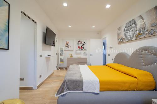 CalangianusVilla Green - Sardegna的一间卧室配有一张带黄色毯子的大床