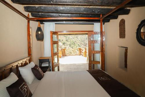 Sūkirahthe suwgra-Al-Jabal Al-Akdar的一间卧室设有一张床和一个开放式门