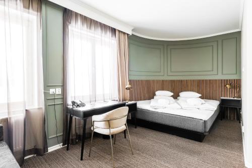 林雪平Comfort Hotel Linköping City的酒店客房配有两张床和一张书桌