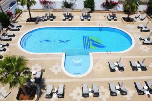 圣安东尼奥湾Hotel Apartamentos Vibra San Marino的享有带躺椅的游泳池的顶部景致
