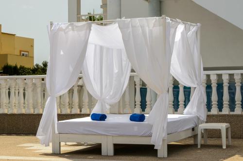 圣安东尼奥湾Hotel Apartamentos Vibra San Marino的阳台的白色窗帘床