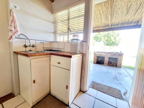 斯韦伦丹Kwetu Guest Farm的一个带水槽和大窗户的厨房
