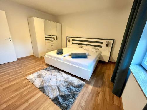 菲拉赫AB Apartment Moderne Zweizimmerwohnung的卧室配有白色的床和地毯。