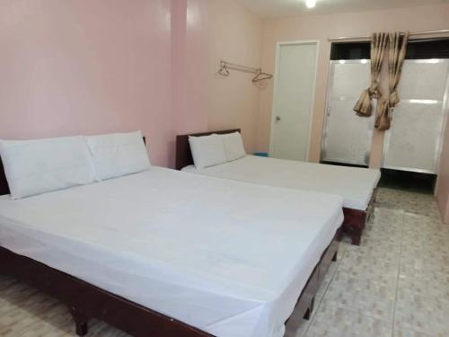 宿务Cebu Leisure Lodge的窗户客房内的一张大白色床