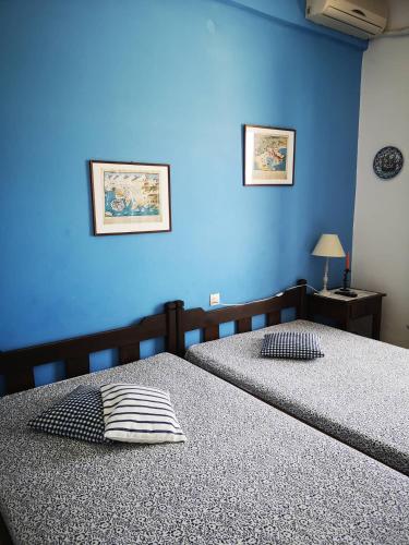 费索斯Maria's Studios blue的卧室设有两张床铺,拥有蓝色的墙壁