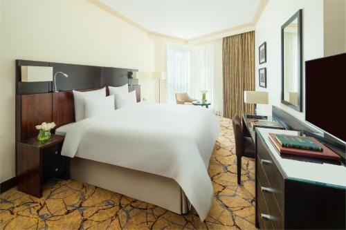 麦加麦加哈加塔瑞享酒店的酒店客房设有一张白色大床和一张书桌