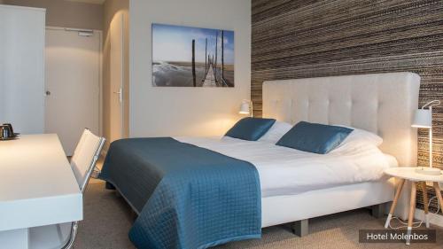 德科克斯多普莫棱博斯特克塞尔酒店的卧室配有带蓝色枕头的大型白色床