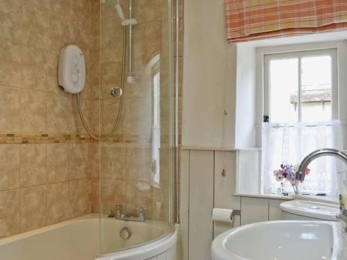 斯多克兰Fern Dale Cottage的带淋浴、浴缸和盥洗盆的浴室