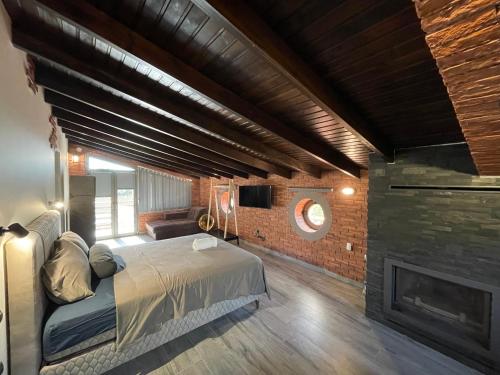 亚历山德鲁波利斯Makri Sunrise Villa的一间卧室配有一张床和一个壁炉