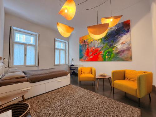 布达佩斯Stylish holiday Art apartment - wifi & great location的一间卧室配有一张床、两把椅子和一幅画