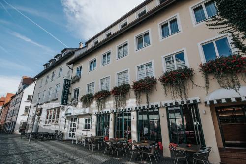 乌尔姆Boutique Hotel am Rathaus - Reblaus的前面设有桌椅的建筑