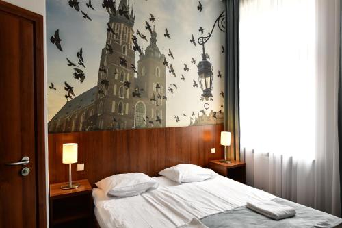 克拉科夫Hotel Downtown Kraków的卧室配有一张大床,墙上有鸟
