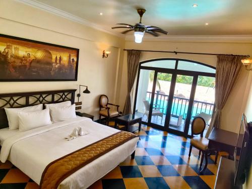 蓬蒂切里Lagoon Sarovar Premiere Resort - Pondicherry的一间卧室设有一张大床,铺有 ⁇ 格地板